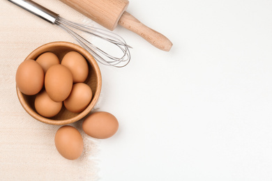 Photo of Flat lay composition with raw eggs on white table, space for text. Baking pie