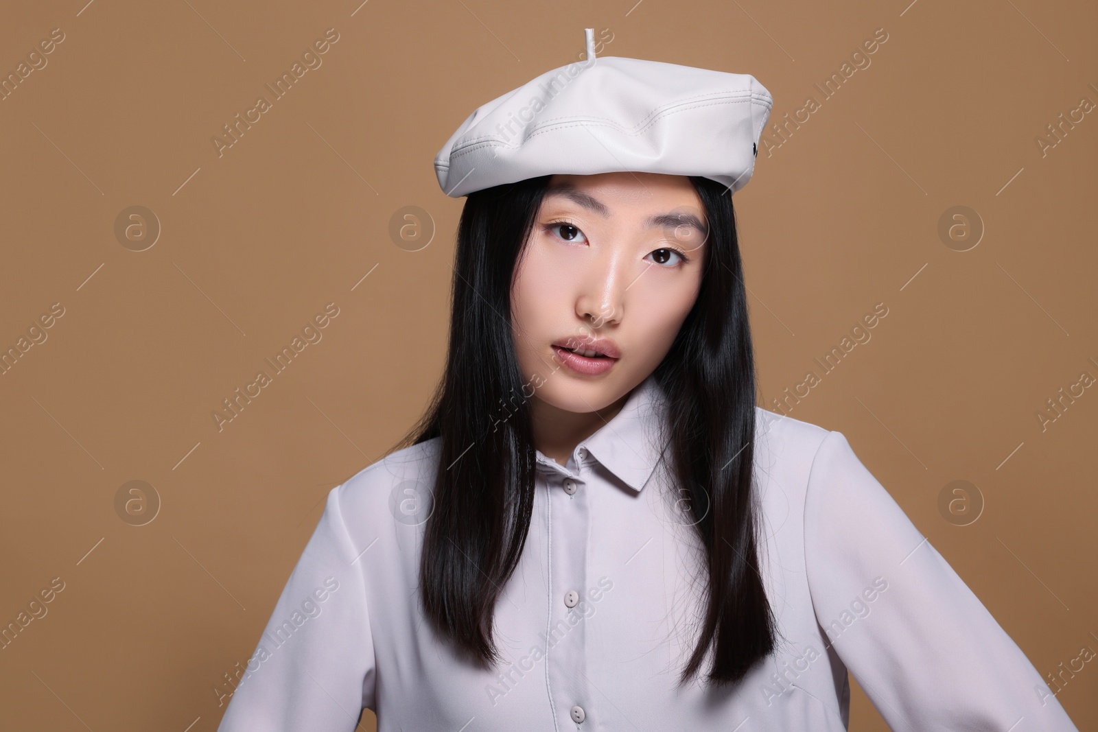 Photo of Portrait of beautiful young Asian woman in stylish outfit on beige background