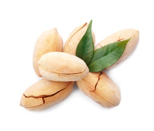 Photo of Heap of pecan nuts in shell and leaves on white background, top view