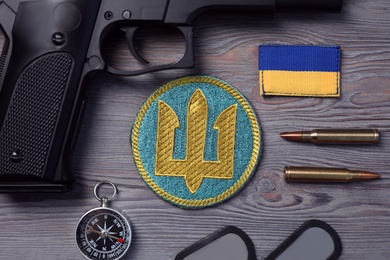 Photo of Flat lay composition with Ukraine military equipment on grey wooden table