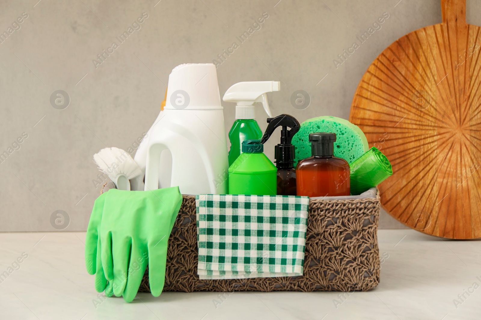 Photo of Different cleaning supplies in basket on countertop