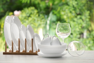 Photo of Set of clean dishware on table against blurred background