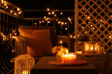 Photo of Beautiful view of garden furniture with pillow and burning candles at balcony