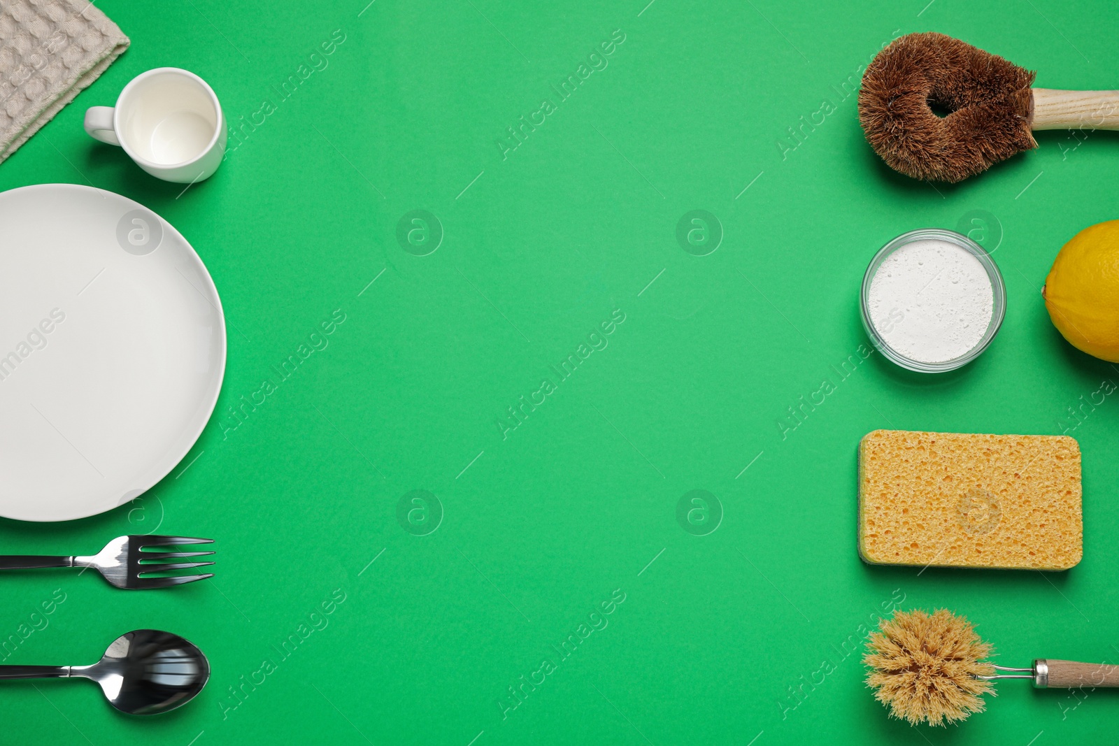 Photo of Tableware and cleaning supplies for washing dishes on green background, flat lay