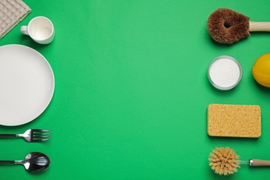 Tableware and cleaning supplies for washing dishes on green background, flat lay