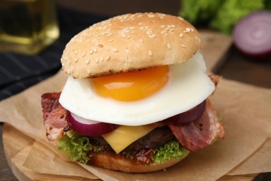 Photo of Delicious burger with fried egg on table, closeup