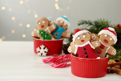 Photo of Delicious homemade Christmas cookies on white wooden table against blurred festive lights. Space for text