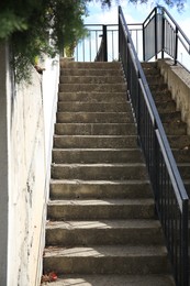 Photo of View of beautiful concrete stairs with metal handrail outdoors