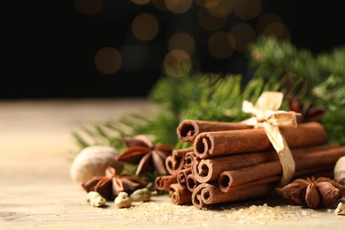 Different aromatic spices on wooden table against black background, closeup. Space for text