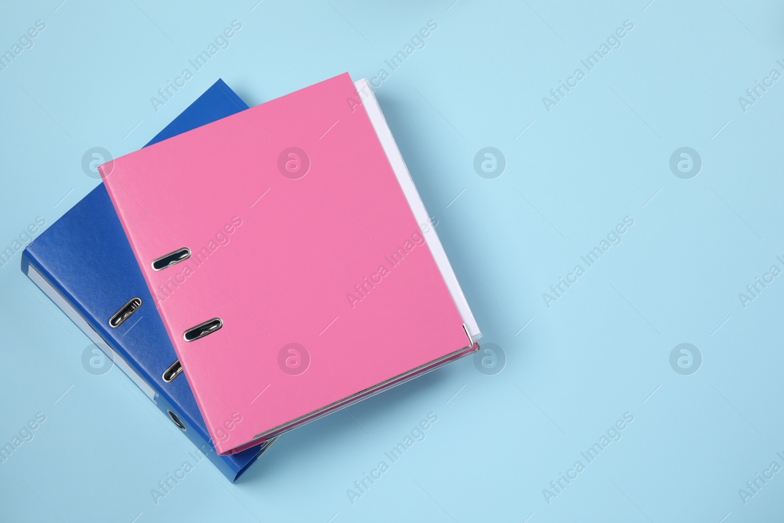 Photo of Office folders on light blue background, flat lay. Space for text