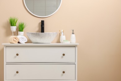 Photo of Different bath accessories and personal care products near sink on bathroom vanity, space for text