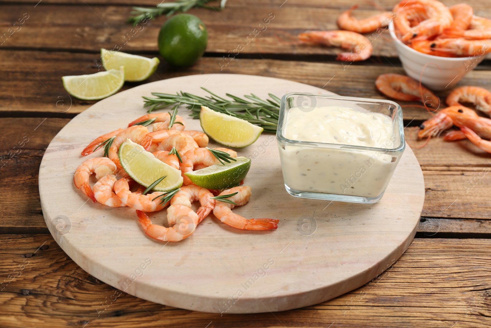 Photo of Delicious shrimp cocktail and tartar sauce served on wooden table