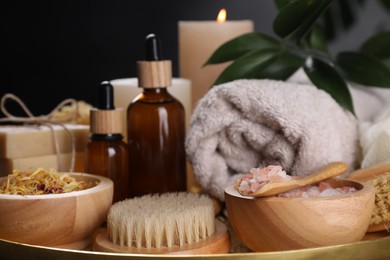 Spa composition. Brush, bottles and sea salt on tray, closeup