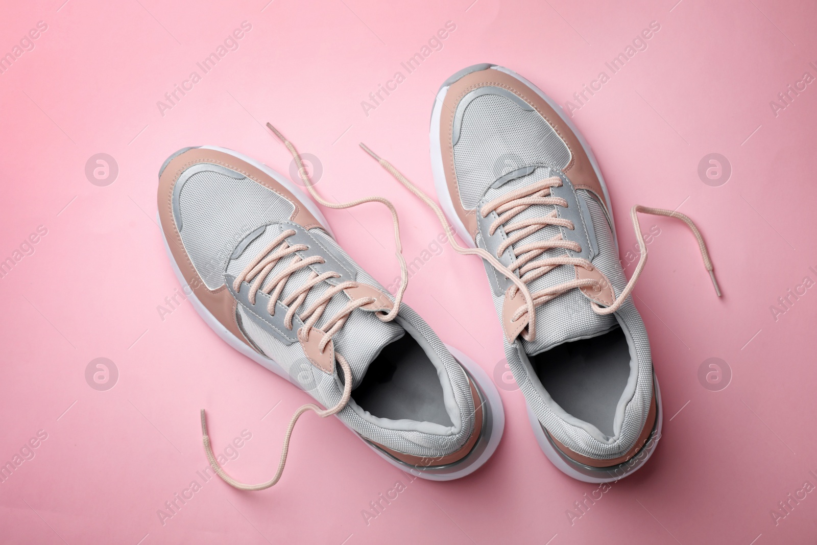 Photo of Pair of stylish sneakers on color background, top view