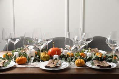 Photo of Beautiful autumn table setting. Plates, cutlery, glasses, pumpkins and floral decor