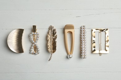Photo of Stylish hair clips on white wooden table, flat lay