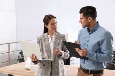 Businesswoman helping intern with work in office