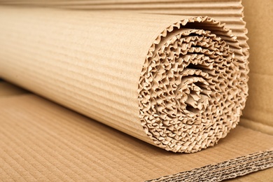 Photo of Roll of brown corrugated cardboard, closeup. Recyclable material