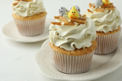 Tasty Easter cupcakes with vanilla cream on white table, closeup