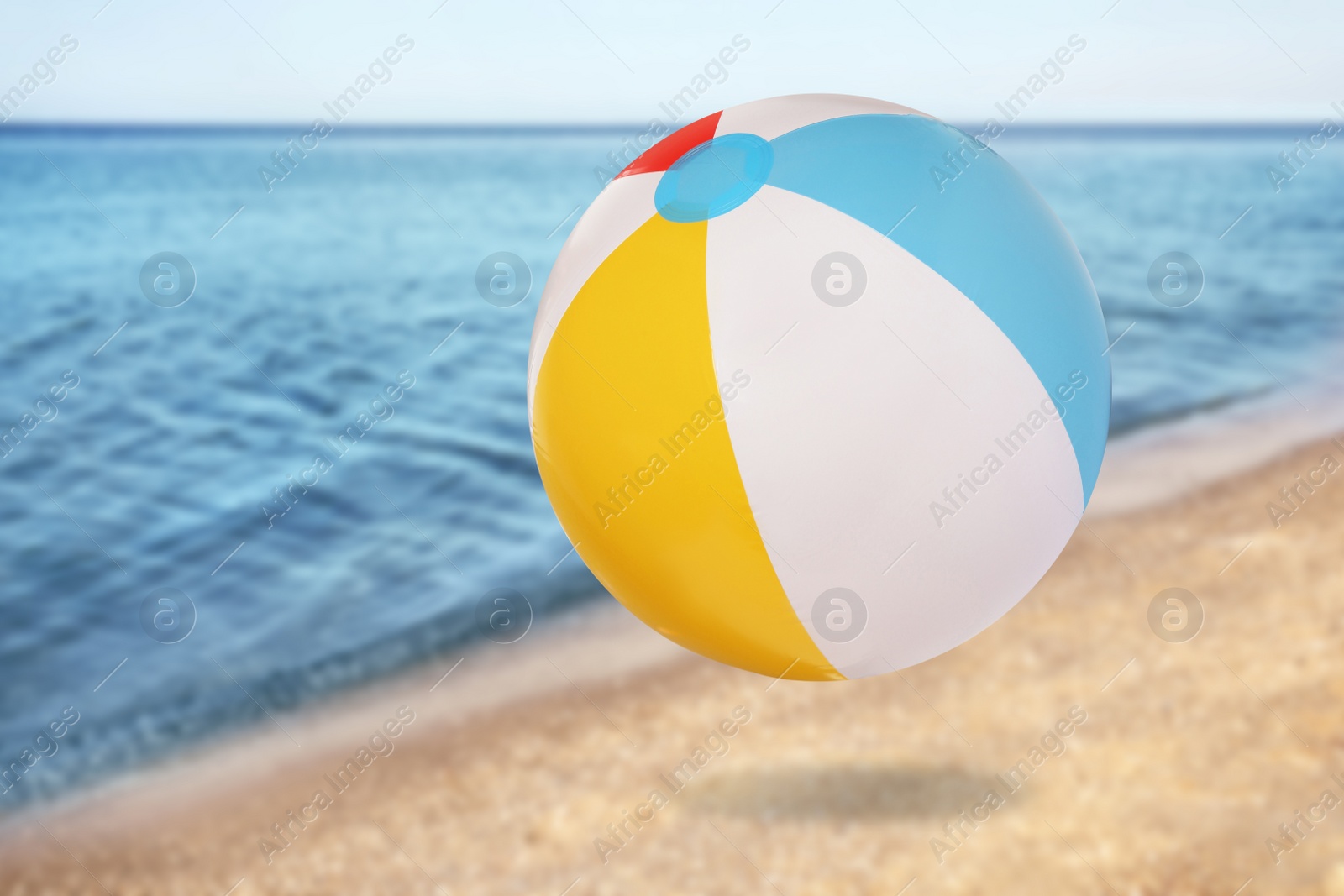 Image of Colorful inflatable beach ball and seascape on background