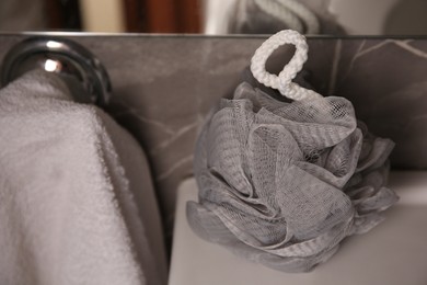 Photo of Grey shower puff on sink in bathroom, closeup