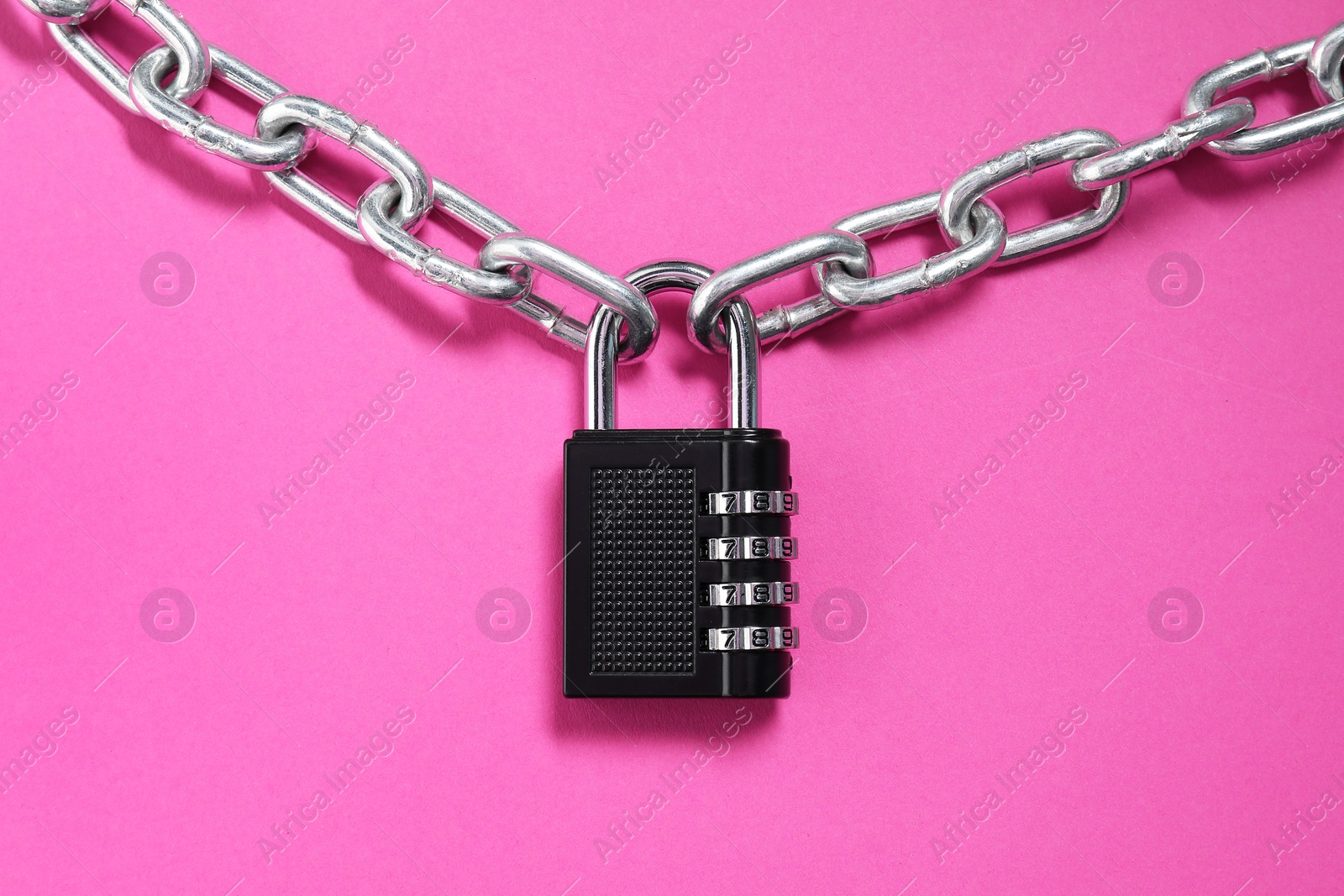 Photo of Steel combination padlock and chain on pink background, top view
