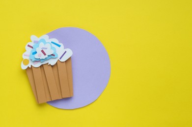 Photo of Birthday party. Paper cupcake on yellow background, top view with space for text