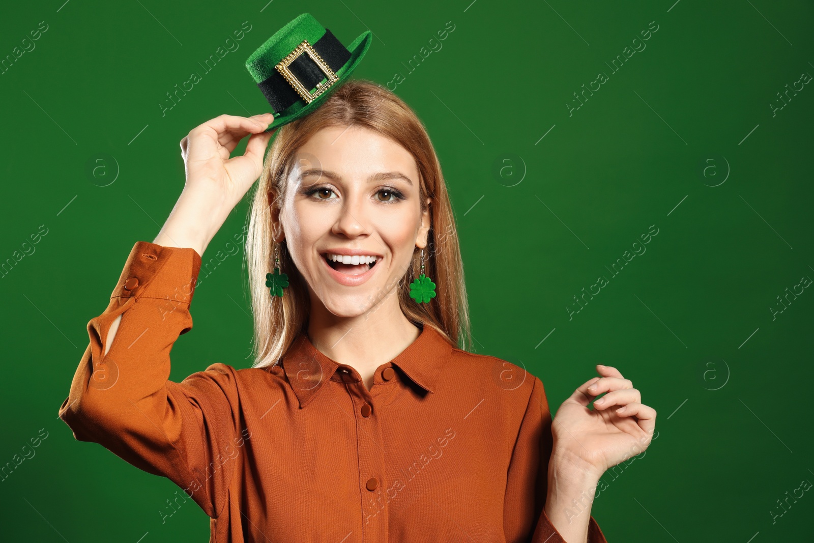 Photo of Young woman with leprechaun hat on green background. St. Patrick's Day celebration