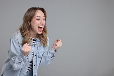 Photo of Portrait of happy surprised woman on grey background. Space for text