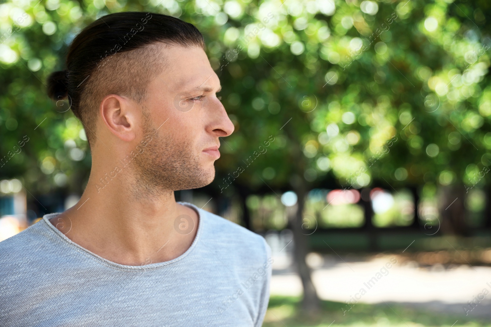 Photo of Portrait of handsome young man in park, space for text