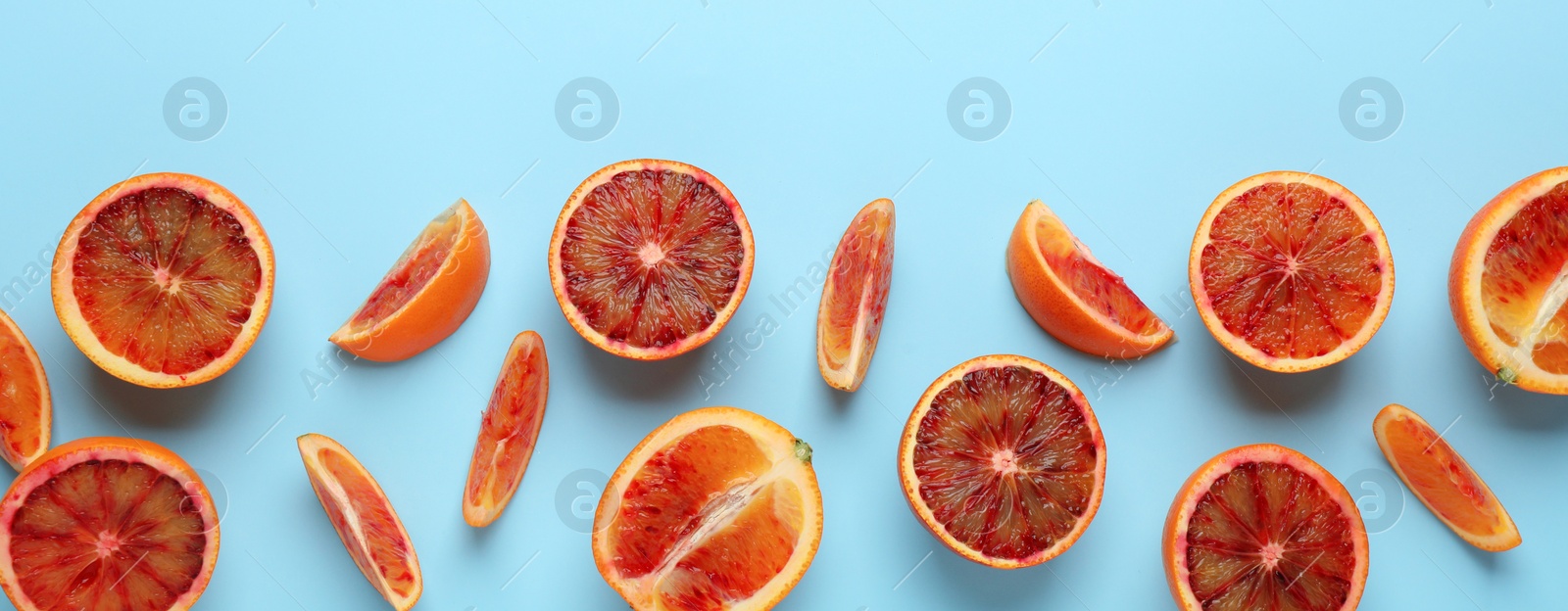 Image of Many ripe sicilian oranges on light blue background, flat lay with space for text. Banner design