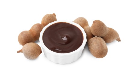 Photo of Bowl of tasty tamarind sauce and fresh pods isolated on white