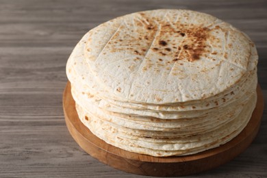Photo of Many tasty homemade tortillas on wooden table
