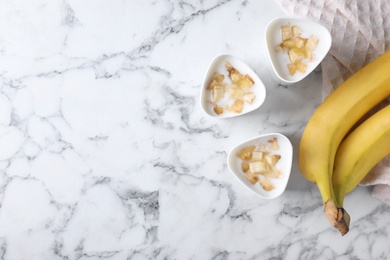 Photo of Flat lay composition with cups of banana yogurt on table, space for text. Multi cooker recipe