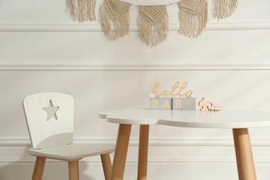 Photo of Modern child room interior with white table and cubes