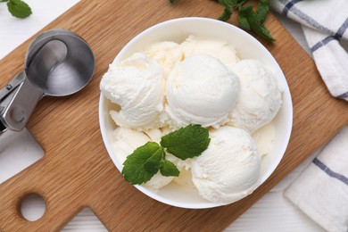 Photo of Delicious vanilla ice cream, mint and scoop on white table, flat lay