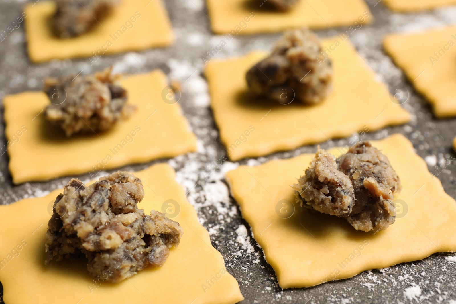 Photo of Making ravioli on grey table, closeup. Italian pasta