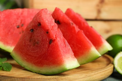 Photo of Slices of delicious watermelon and limes on light blue wooden table, closeup