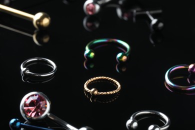 Photo of Stylish jewelry for piercing on black background