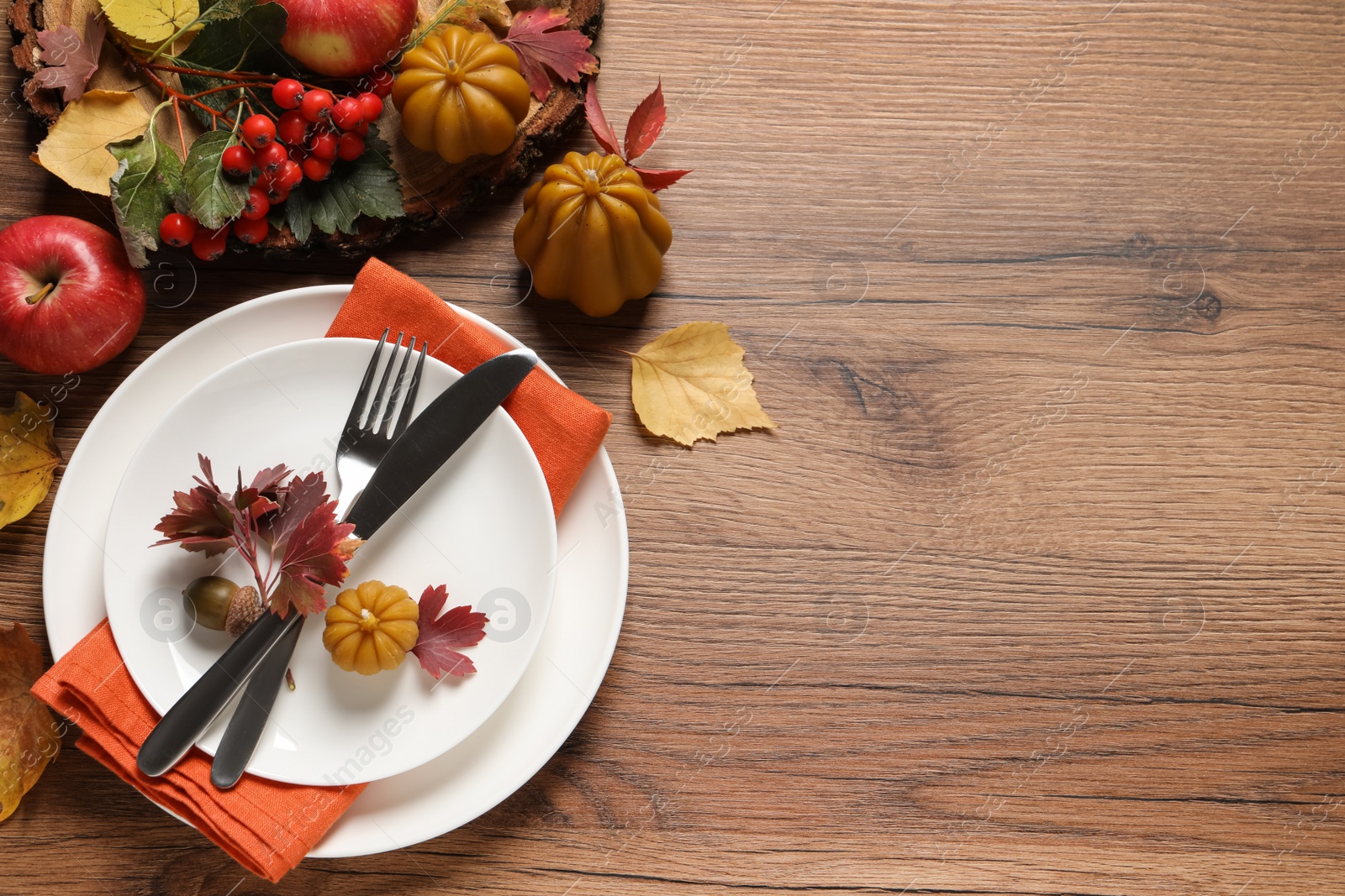 Photo of Festive table setting with autumn decor on wooden background, flat lay. Space for text