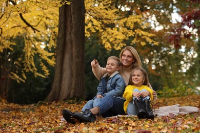 Happy mother spending time together with her children in autumn park