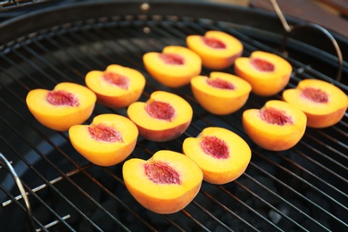 Modern grill with tasty cut peaches outdoors, closeup