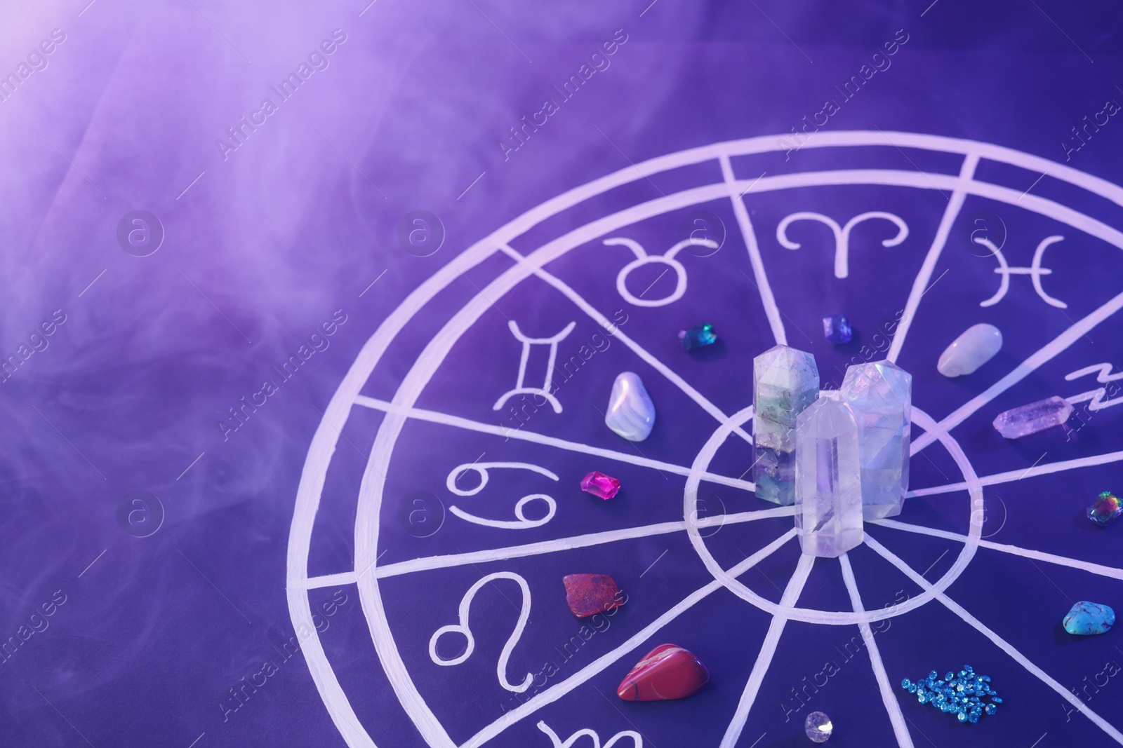 Photo of Natural stones for zodiac signs and drawn astrology chart on dark blue background, space for text. Color tone effect