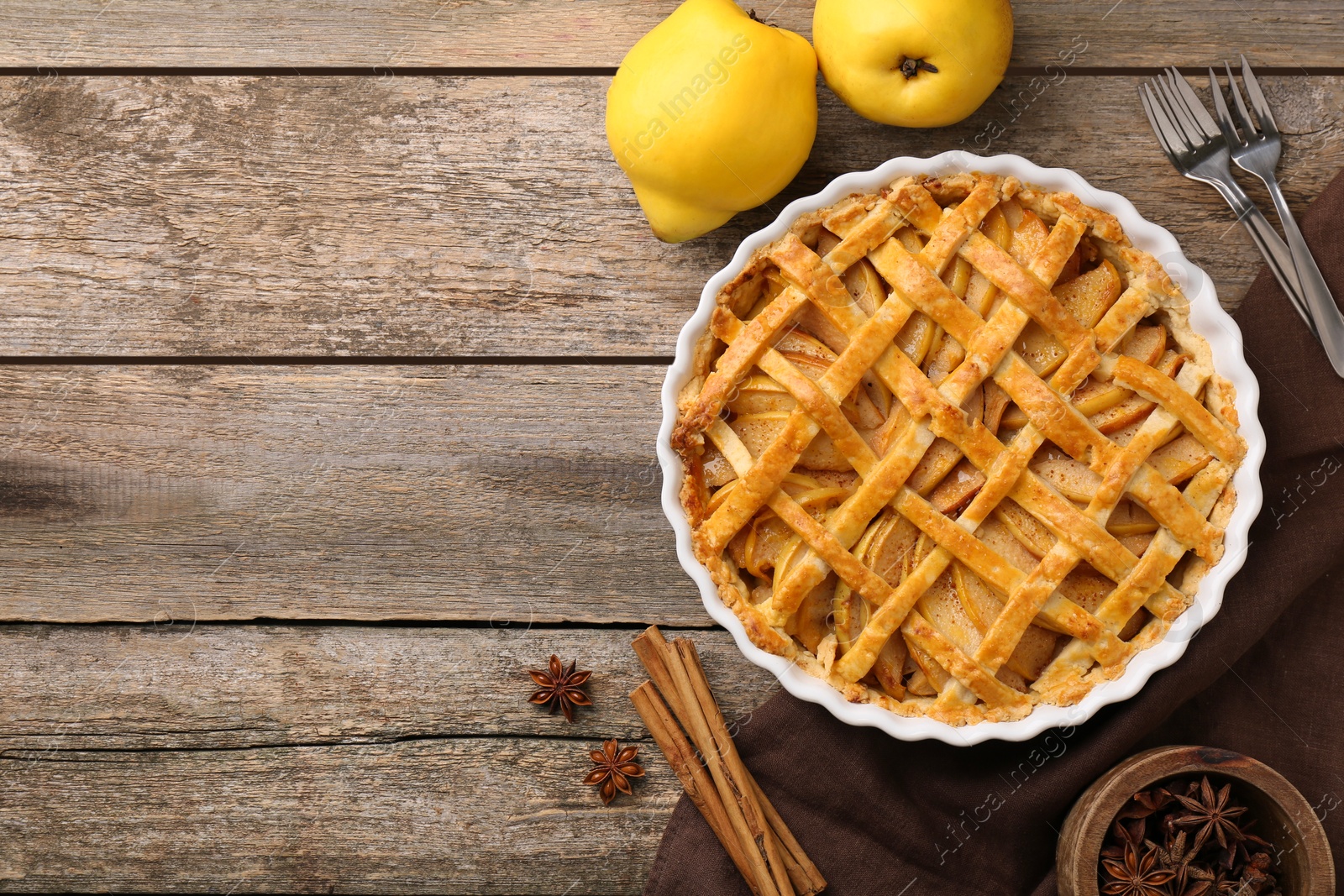 Photo of Tasty homemade quince pie served on wooden table, flat lay. Space for text