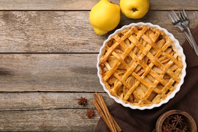 Tasty homemade quince pie served on wooden table, flat lay. Space for text