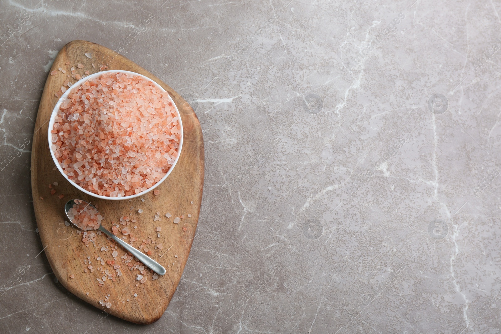 Photo of Pink himalayan salt on grey table, flat lay. Space for text