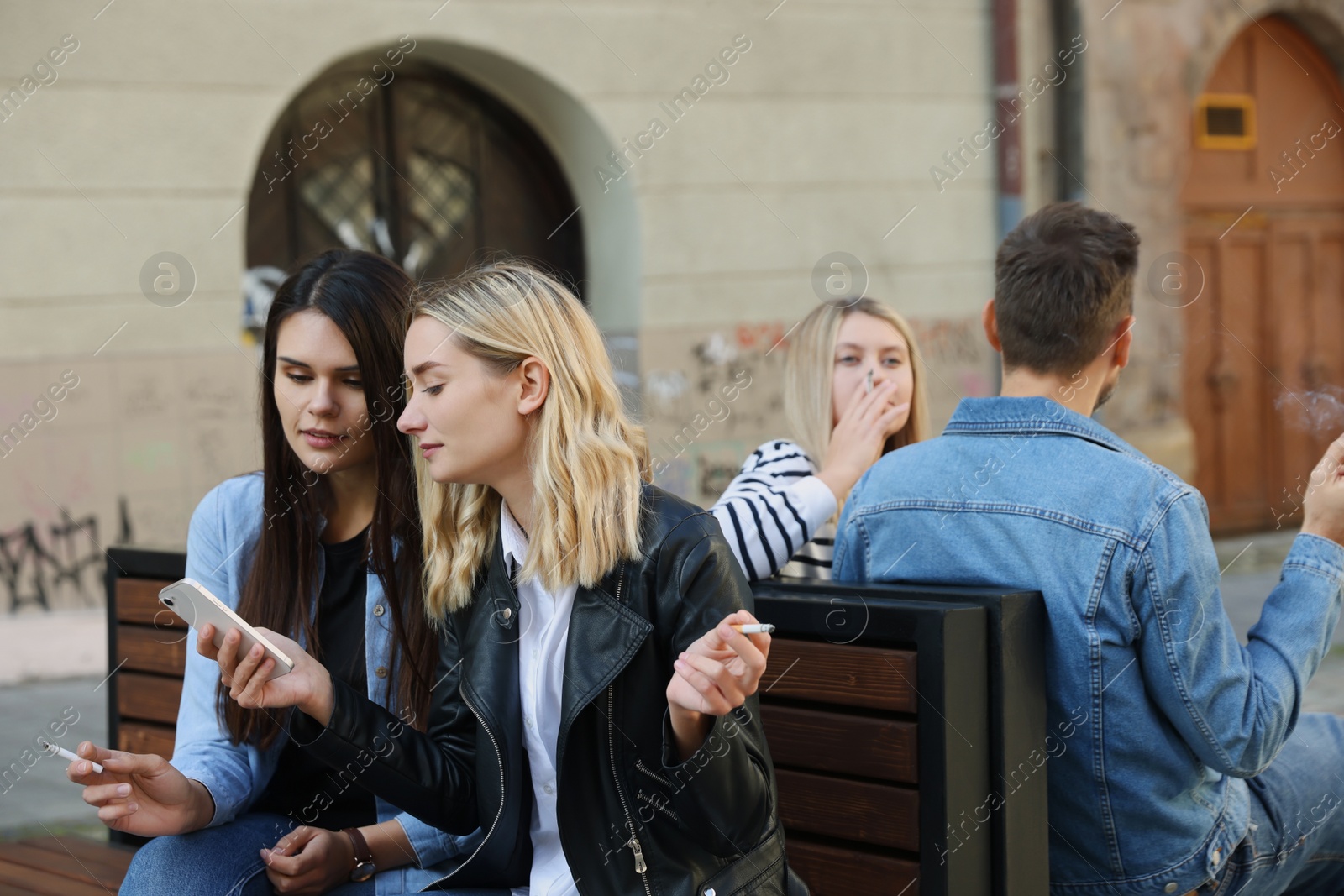 Photo of People smoking cigarettes at public place outdoors