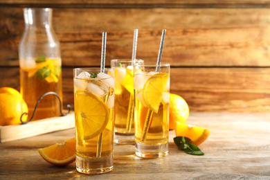 Delicious refreshing drink with orange slices on wooden table