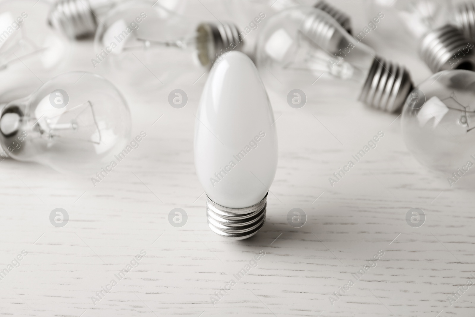 Photo of Frosted and transparent lamp bulbs on white wooden table