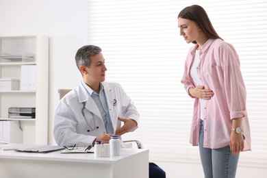 Gastroenterologist consulting patient with stomach pain in clinic